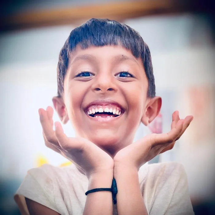 A smiling child, full of curiosity and possibility